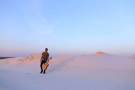 阿拉伯的家伙去美丽的沙漠的鼓舞和起吉他 stri