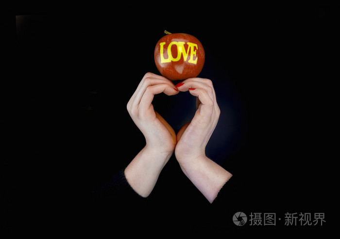 两个女人手中的一颗心和一个苹果与爱字的形状