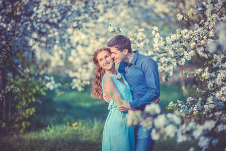 年轻美丽的夫妇，在苹果树林中的爱