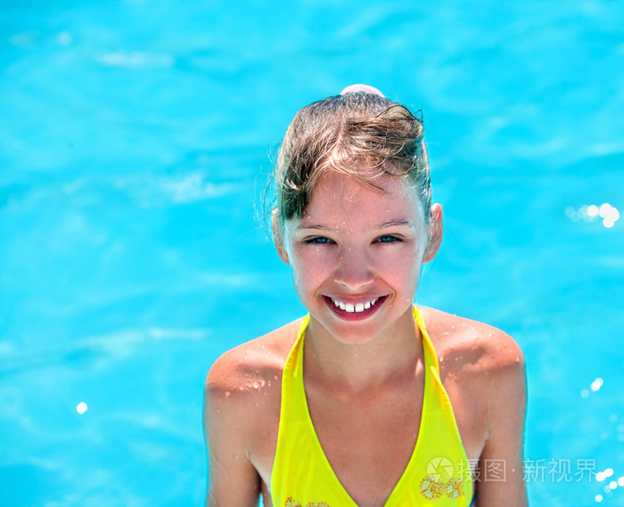 孩子在游泳池里的黄色比基尼