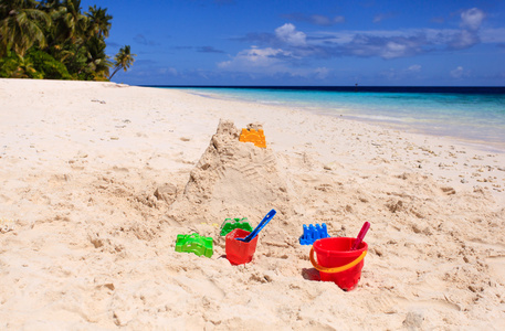 海滩和孩子们的玩具上的沙堡