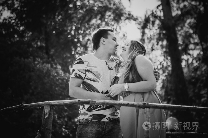 黑白色的摄影浪漫的年轻情侣接吻和站在背景上桥照片-正版商用图片0dj