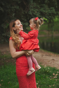 快乐妈妈带着女儿在红色礼服