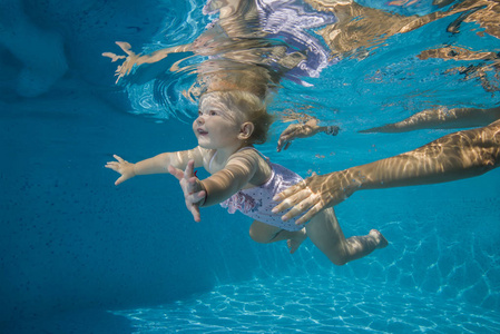 小的孩子们学习水下在游泳池里游泳