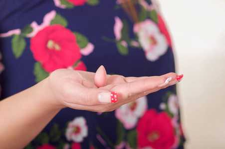 关闭女人的手，她打开的手里拿着软明胶片或栓剂，生殖器官的妇女和女性的健康预防疾病的治疗