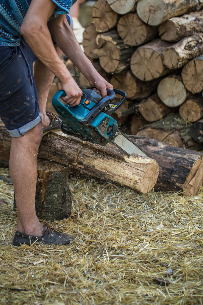 男人用链锯砍木头