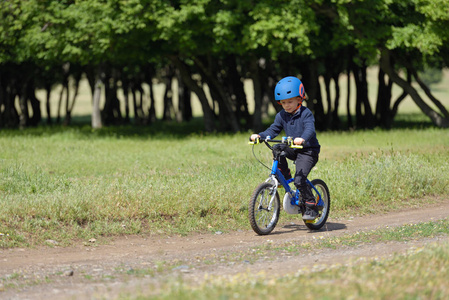 快乐的孩子男孩 5 年开心春林用一辆自行车上美丽的秋季的一天。活跃的孩子戴着自行车头盔