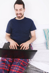 男人在床上使用笔记本电脑