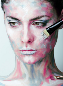 年轻女人有创意化妆像脸上涂的油图片