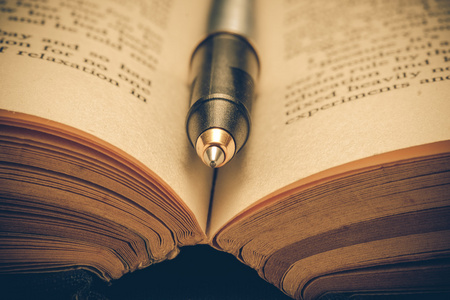 筛选器效果复古怀旧风格的书和笔照片