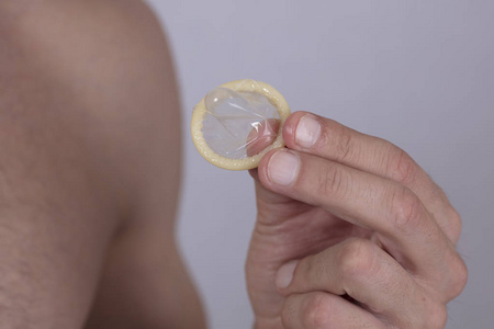 男手控股避孕套.预防性传播疾病.卫生保健和性病的预防概念照片