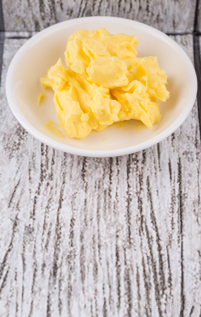 人造黄油在木制的背景白色碗一碗