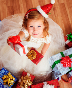 小女孩用圣诞或生日礼物坐在地板上