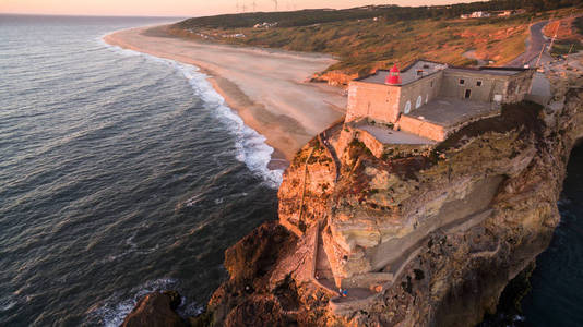 海洋，北部海滩和 Nazare 灯塔在日落时，葡萄牙的鸟瞰图