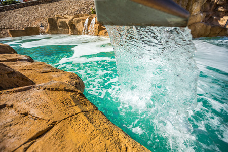 室外游泳池的人工瀑布流出水图片