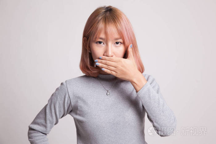 年轻的亚洲女人闭上她的嘴用一只手