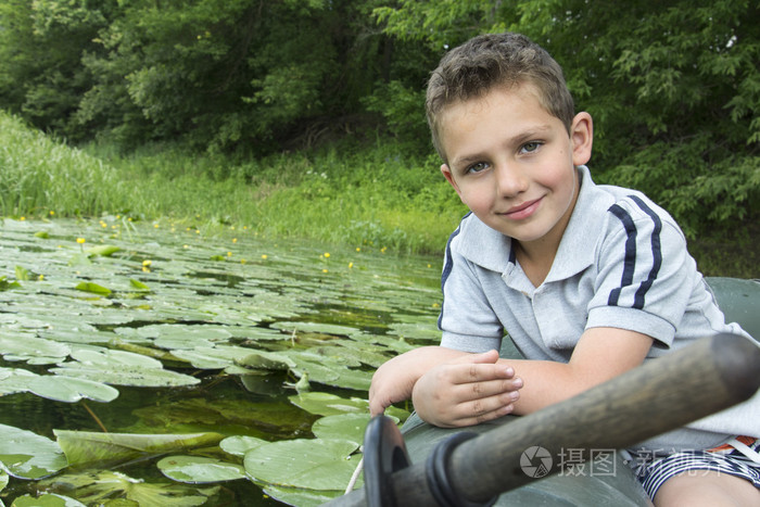 在夏天在河里一个小男孩坐在橡皮船