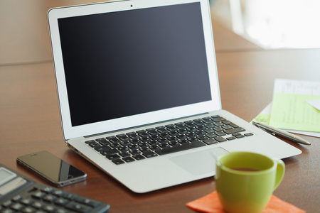 在现代的木桌子上打开笔记本电脑工作场所照片