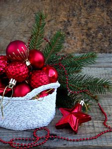 白色钩针圆篮子用红色圣诞装饰一对木制背景。新年和圣诞节卡背景。复制空间。选择性的焦点