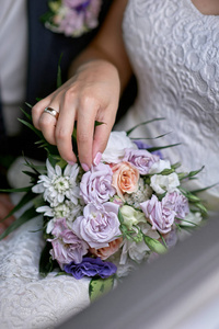 新娘把她的手放在婚礼花束
