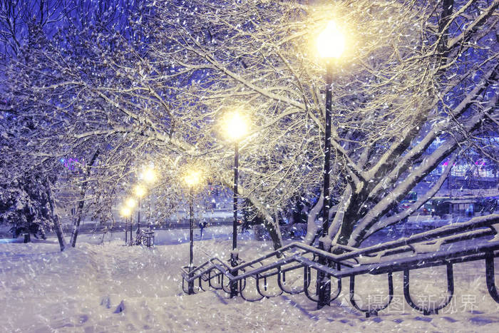 冬天的场景.在夜晚公园与灯笼的降雪.圣诞节背景.雪花落在雪地上