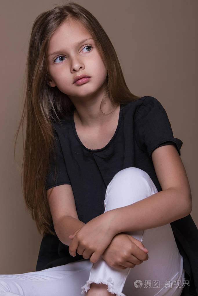 可爱的小女孩,在工作室米色背景的黑头发的画像