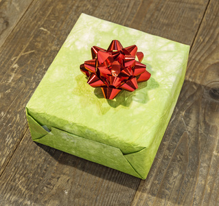 绿色礼品盒木制的桌子上孤立的红色蝴蝶结