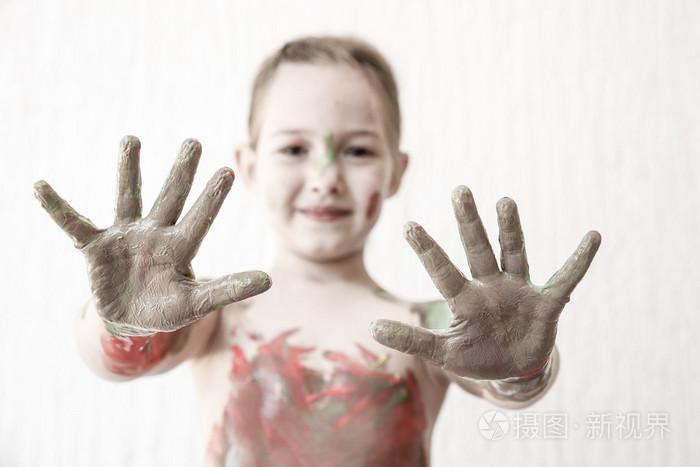 显示她的手，在手指油漆覆盖的小女孩
