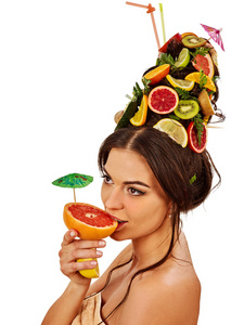 女孩在夏日聚会上喝水果鸡尾酒。女人水果发型