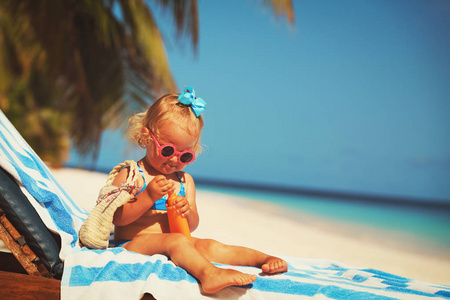 防晒防晒霜在海滩上的小女孩
