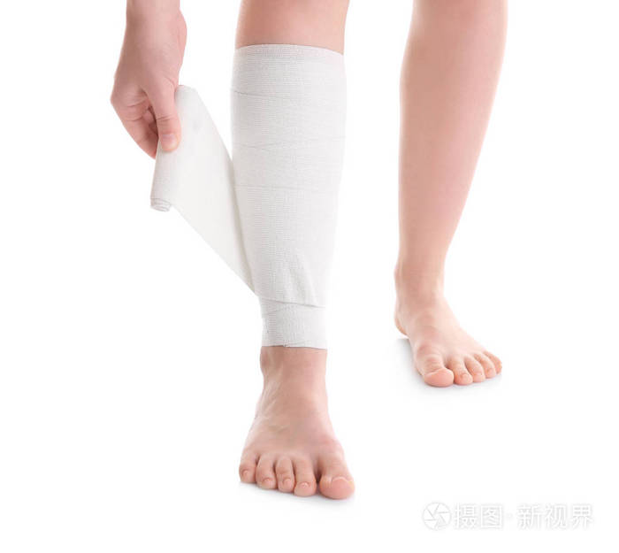 应用到腿上的绷带的年轻女人