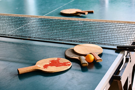 游戏桌上的旧乒乓球球拍。