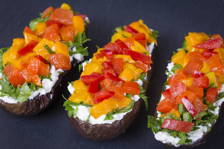 烤茄子塞满蔬菜和奶酪黑色板岩背景上的，关闭