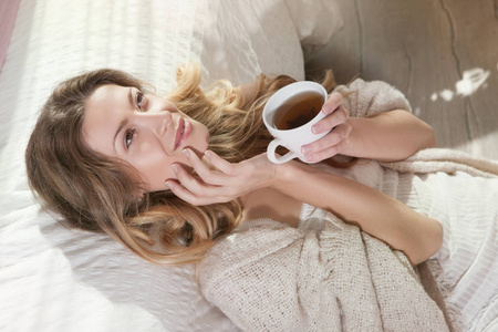 女人躺在床上喝杯茶