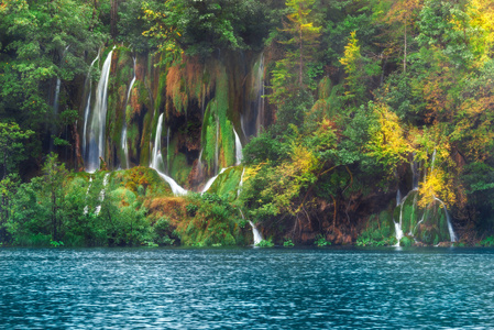 克罗地亚。十六湖。在秋天的树木与湖附近的山坡上的瀑布