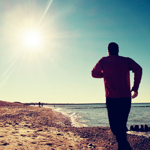 黑 sportswer 跑步和锻炼石质海滩在防波堤上的高个子男人