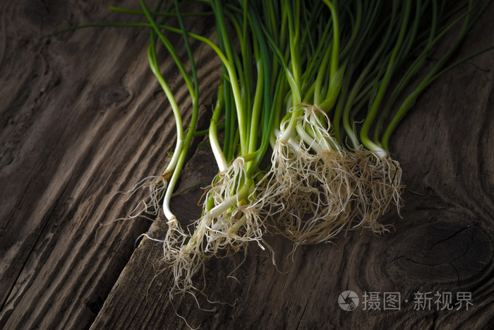 绿色的洋葱茎与根旧主板上
