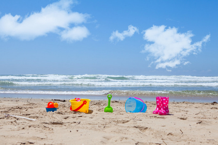 躺在沙滩上的沙子的五颜六色的塑料沙滩玩具