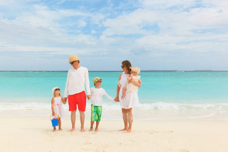 幸福的家庭，和三个孩子走在海滩上