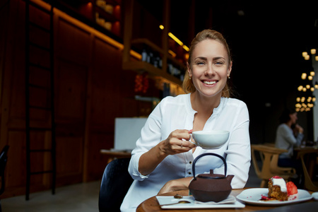 有魅力的女人拿着一杯茶