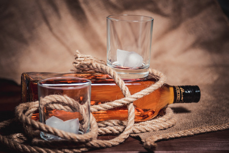 威士忌酒玻璃与冰 一瓶威士忌和一根绳子