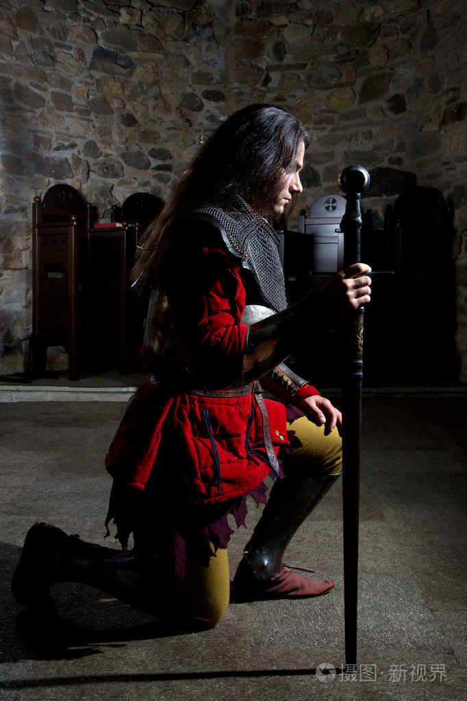 骑士与剑在老教堂做礼拜的侧视图