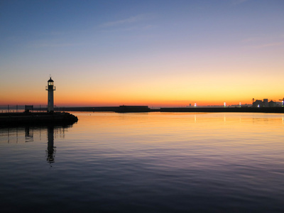 在日落时港口的灯塔