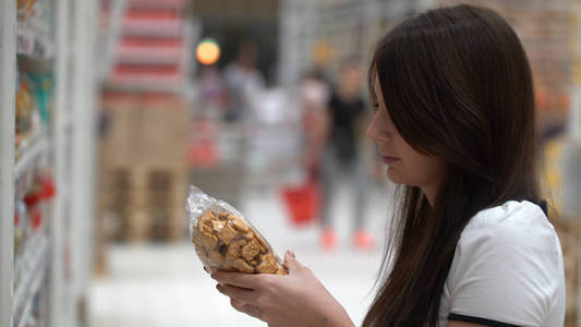 女孩买饼干在商店或超市图片