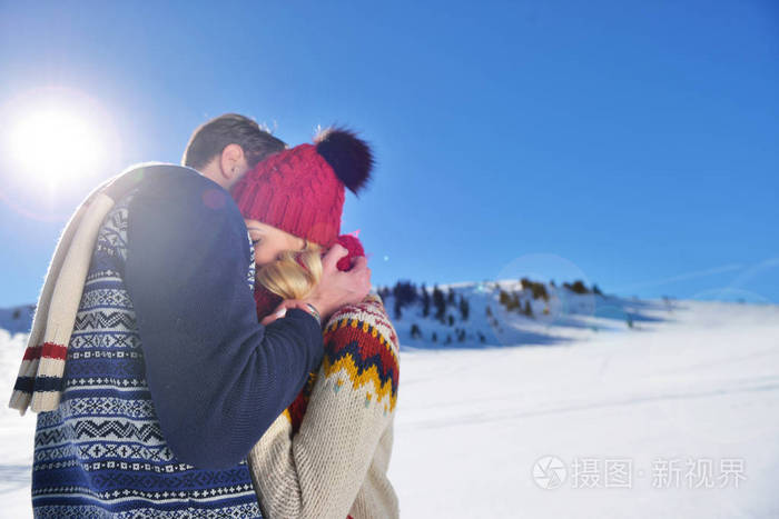 在冬季公园拥抱的恩爱夫妻.他们把彩色软帽和围巾