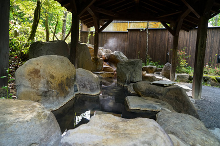 室外的脚温泉与岩石做的水池和木柱屋顶，库尔