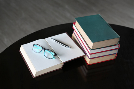 打开的书 精装书和木制的桌子上的眼镜。教育背景