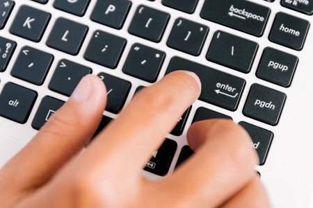 手按下 enter 键在计算机键盘上的按钮照片