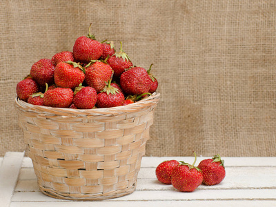 篮子的成熟草莓木制背景上