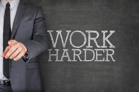 在黑板上更加努力工作,与商人照片